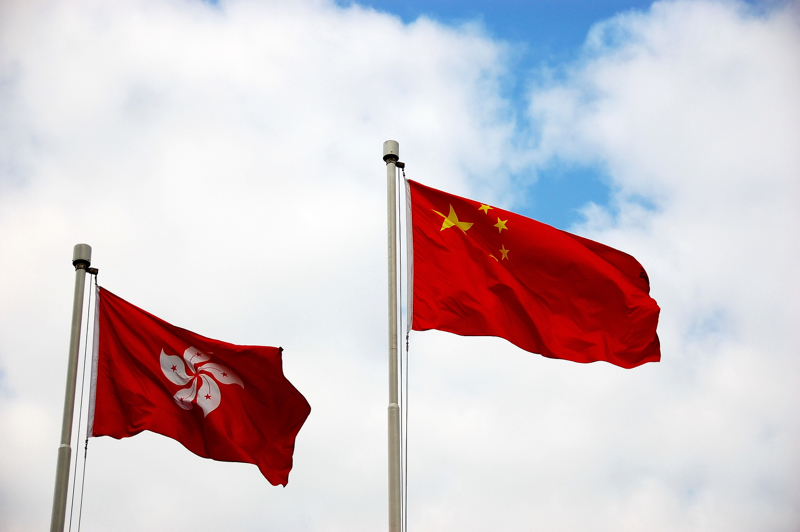Le due bandiere di Hong Kong e Cina fianco a fianco. Foto di Lianquing Li.