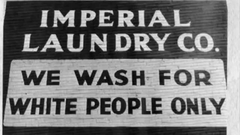 L’insegna di una lavanderia che lavora soltanto per bianchi.