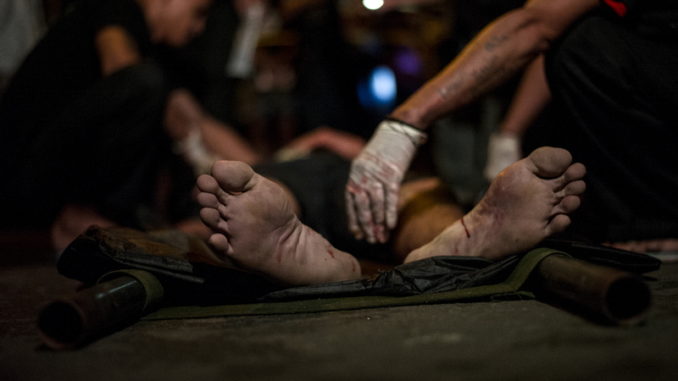 In this picture taken on September 24, 2016, medics check the dead body of an alleged drug dealer gunned down by unidentified men in Manila. Philippine President Rodrigo Duterte defended his threat to kill criminals as "perfect" and vowed no let-up in his war on crime, as the death toll surged past 3,700. / AFP PHOTO / NOEL CELIS